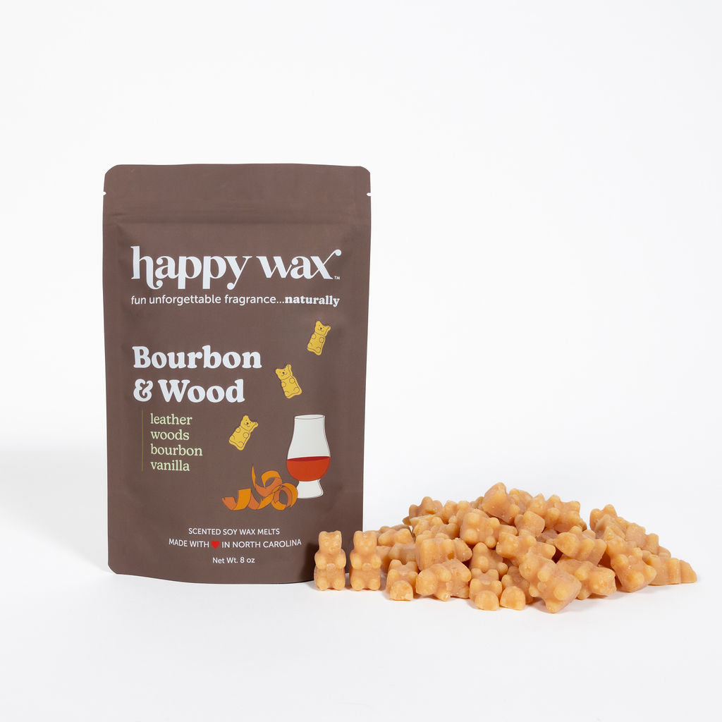 Brown Happy Wax pouch labeled "Bourbon & Wood" next to scattered amber-colored wax melts.