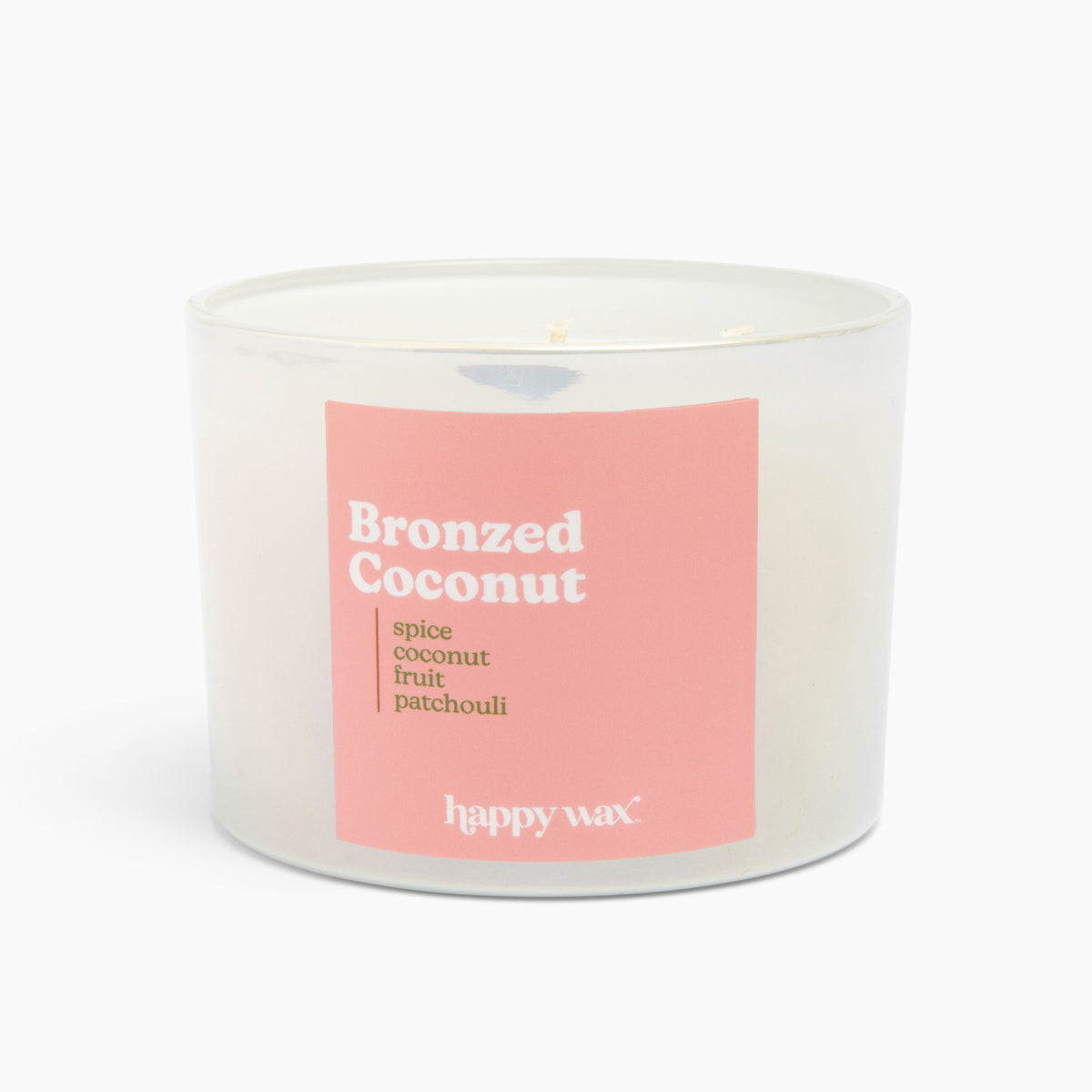 Clear glass cylindrical candle with pink label reading "Bronzed Coconut" and three visible wicks on cream-colored wax.
