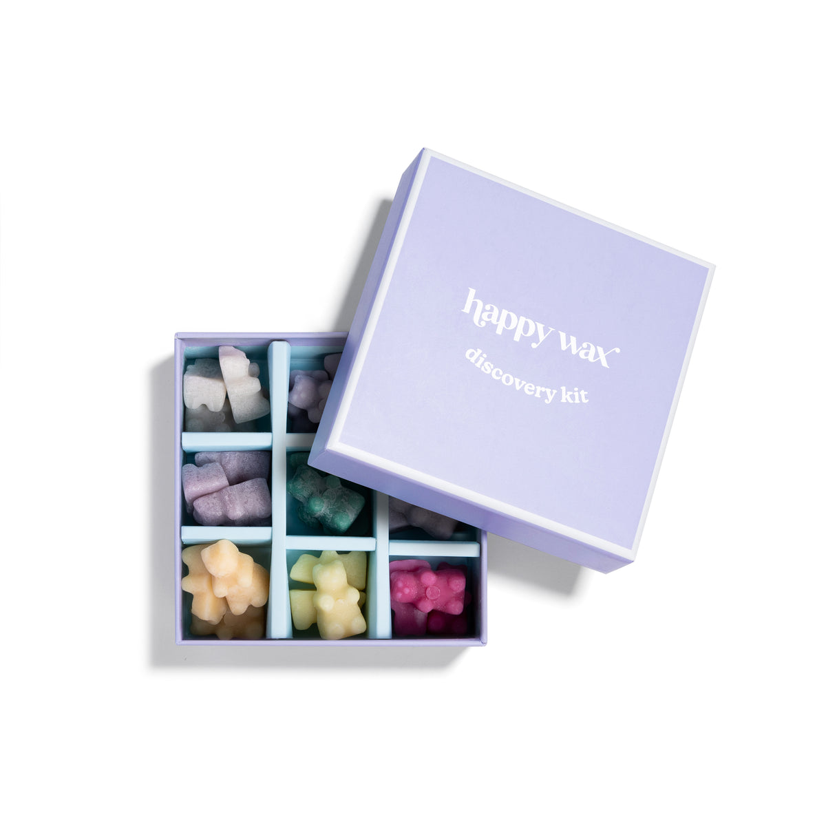 Purple box containing multiple compartments with assorted colored wax melts in various shapes and sizes.