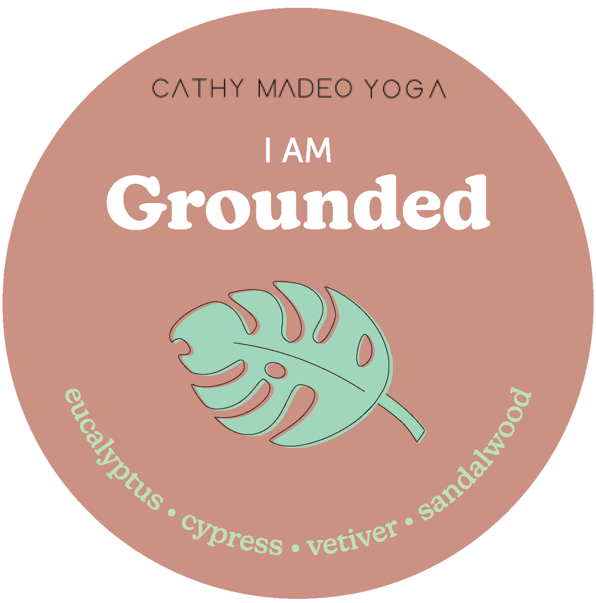 Round terracotta-colored wax melt label with "I am Grounded" text, mint green monstera leaf, and scent notes listed below.