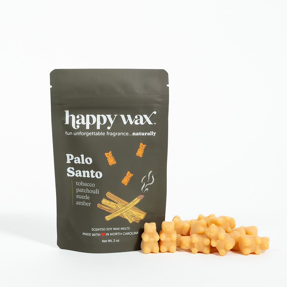 Olive-green pouch of Happy Wax Palo Santo wax melts with beige wax pieces displayed in front.