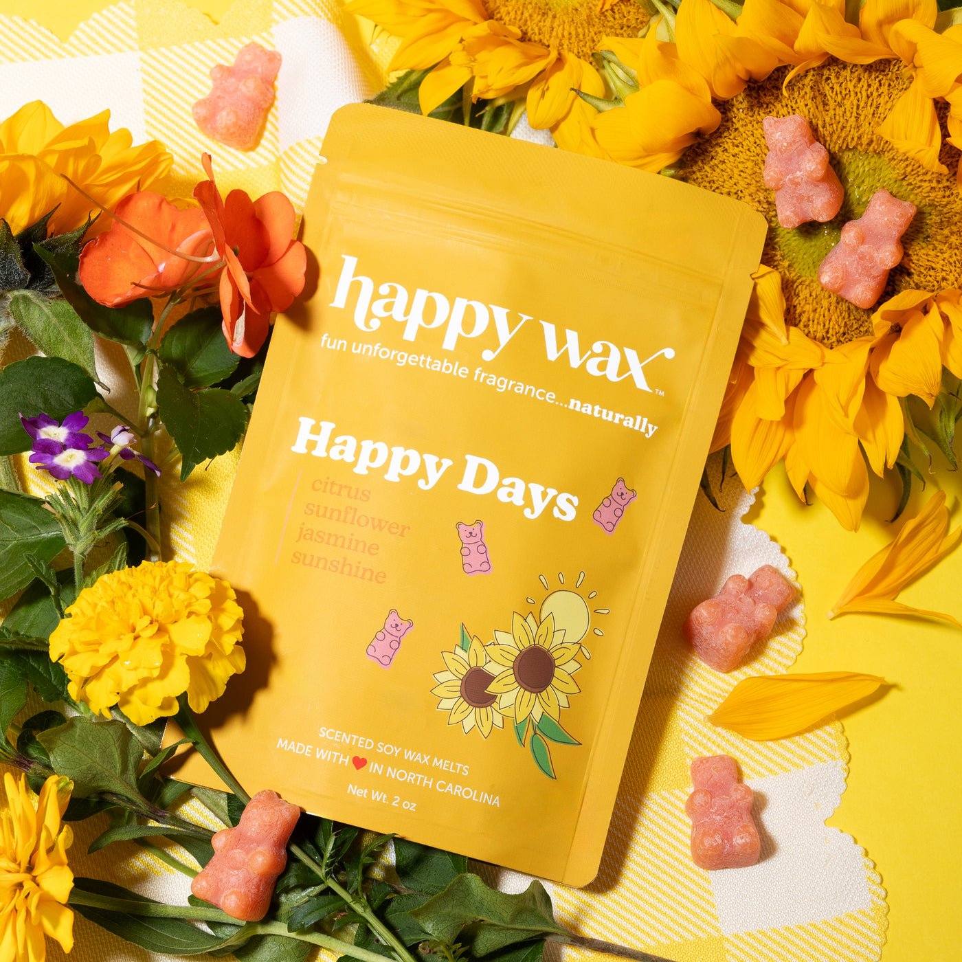 Happy Wax Happy Days with sunflowers and various other flowers with orange wax bears on yellow checkered background
