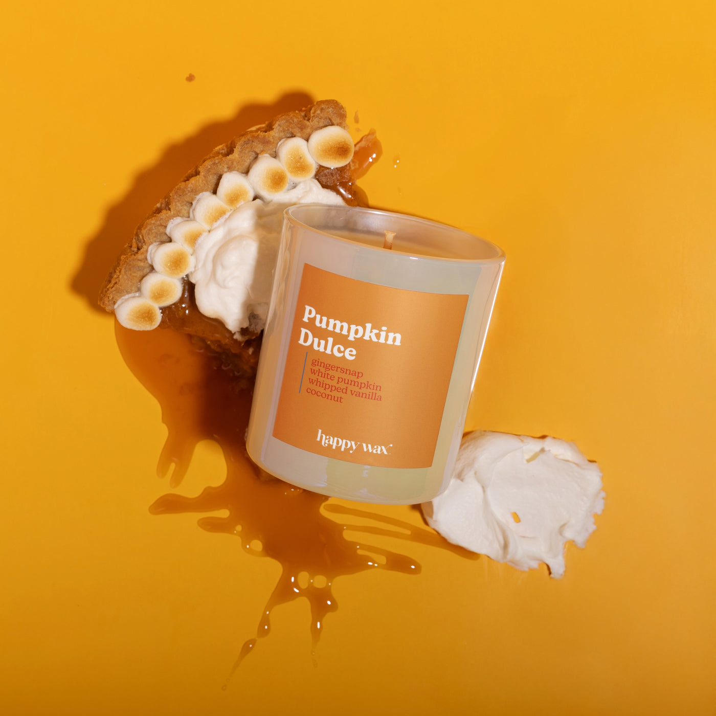 Frosted glass candle jar labeled "Pumpkin Dulce" with single wick, surrounded by graham cracker, toasted marshmallow, and car