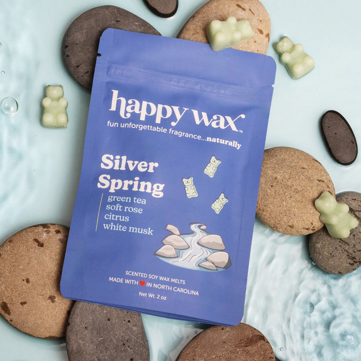 Blue Happy Wax packet of Silver Spring scented soy wax melts surrounded by cream-colored wax melts and cork coasters.