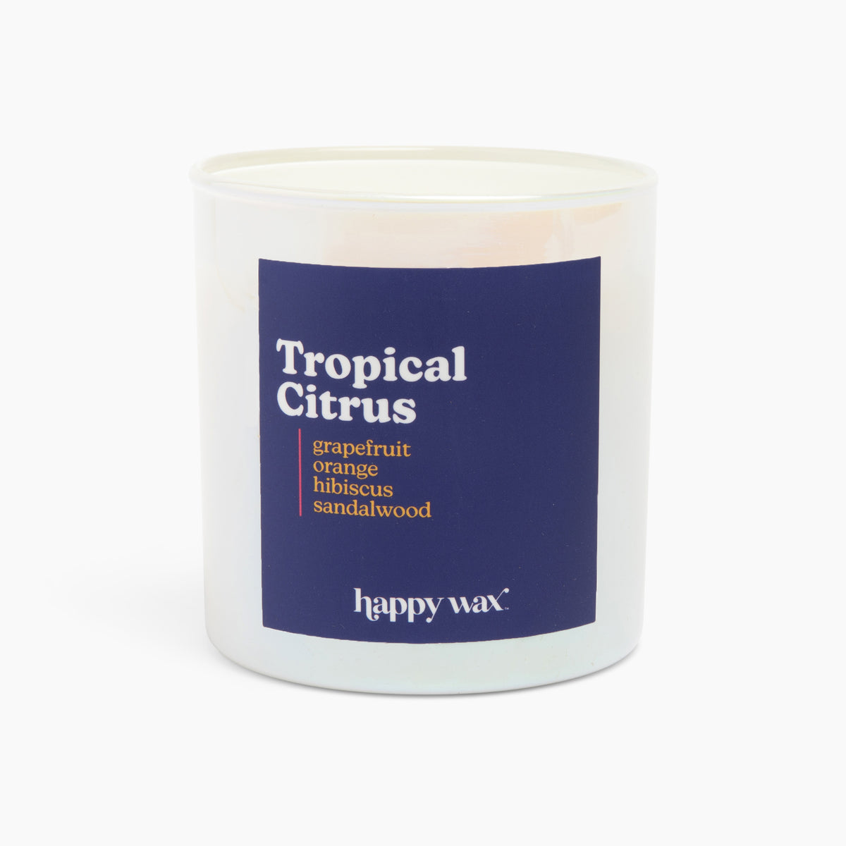White cylindrical candle with navy label reading "Tropical Citrus" and scent notes, single lit wick visible at top.