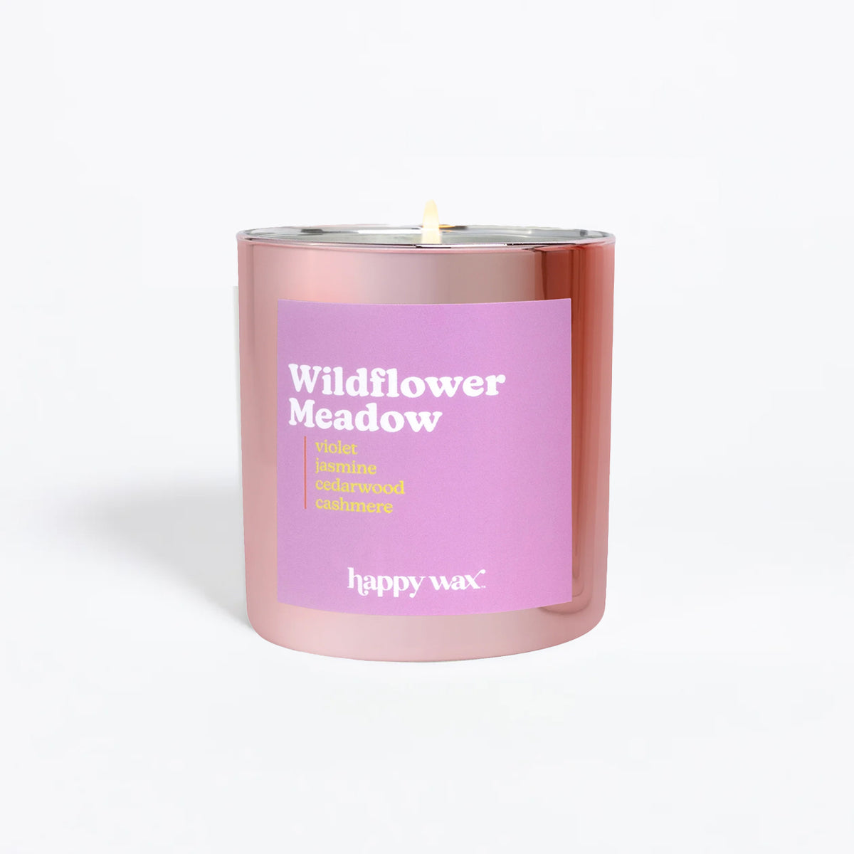 Pink cylindrical candle with purple label reading "Wildflower Meadow" and single lit wick.