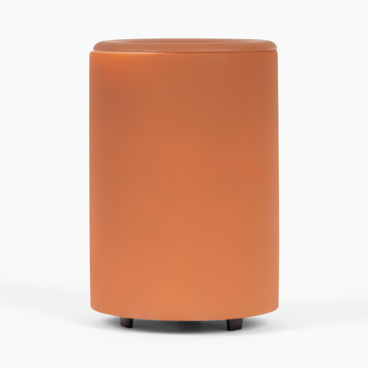 Orange cylindrical wax warmer with rounded top and black feet on white background.