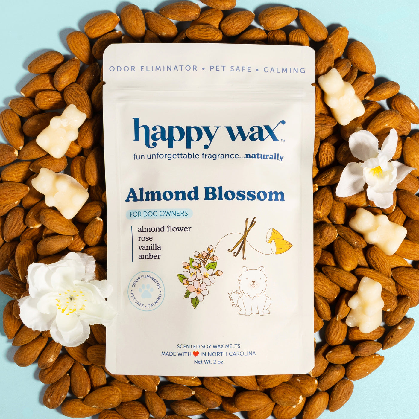 Happy Wax Almond Blossom pet-safe wax melts package surrounded by almonds and white flowers on blue background.