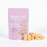 Pink wax melt package labeled "Almond Macaron" with cream-colored cube wax melts displayed beside it.