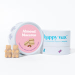 Two bear-shaped wax melts in cream color next to pink-lidded container labeled Almond Macaron and happy wax brand packaging.