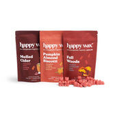 Three pouches of Happy Wax scented soy wax melts in Mulled Cider, Pumpkin Almond Biscotti, and Fall Woods flavors with pink w
