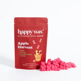 Red Happy Wax pouch with Apple Harvest scent label next to pink wax melt pieces.