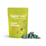 Green resealable pouch of Happy Wax soy wax melts with scattered green wax chunks displayed beside it.