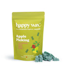 Green pouch of Happy Wax apple picking scented soy wax melts with illustrated apples, displayed next to green wax melt pieces