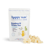Cream-colored wax melts next to a white pouch labeled "Happy Wax Bamboo & White Tea" with cat and tea cup illustrations.