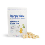 White pouch of Happy Wax bamboo and white tea pet wax melts with cream-colored wax melts displayed beside it.