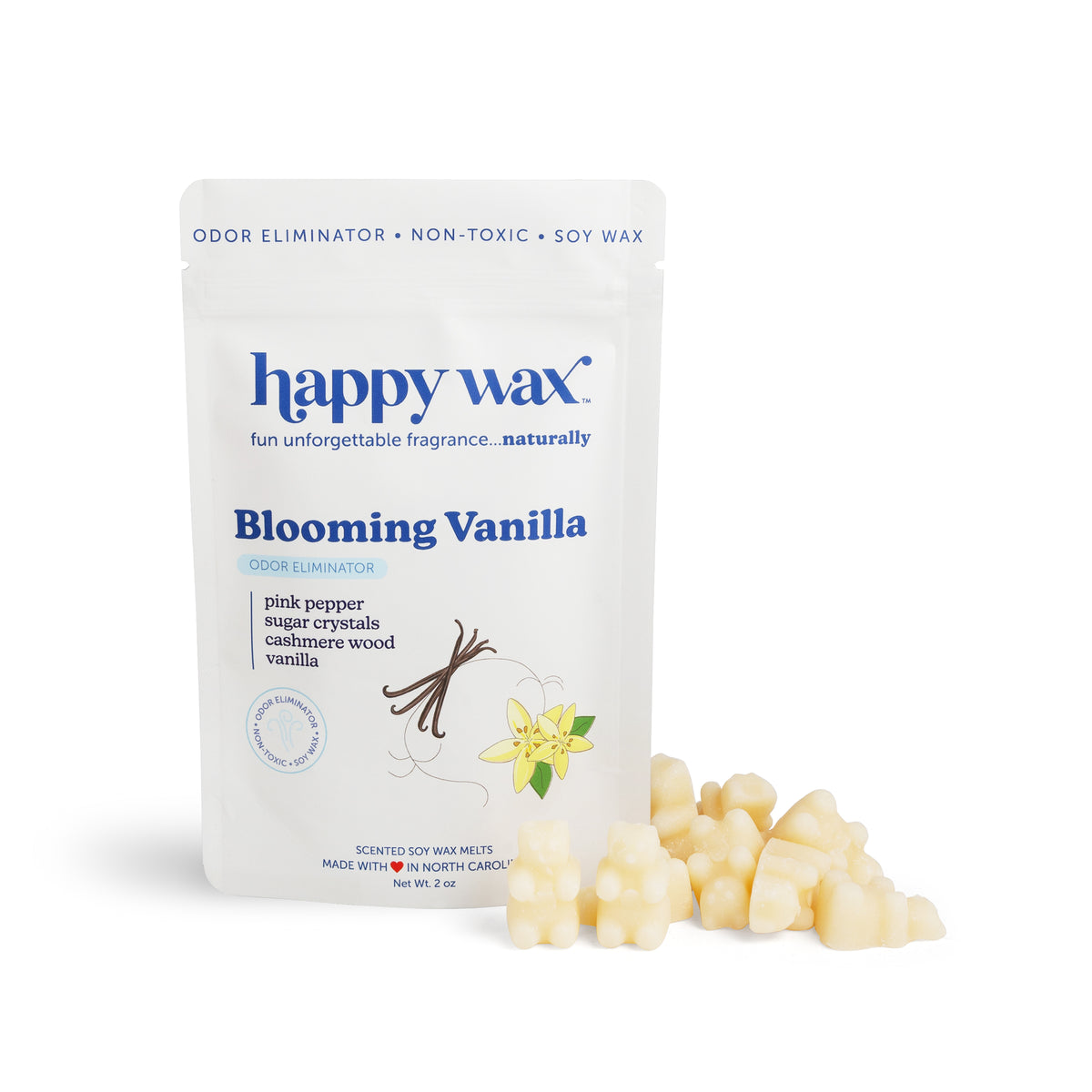 Cream-colored wax melts next to their white pouch labeled "Blooming Vanilla" with ingredient list and brand branding.