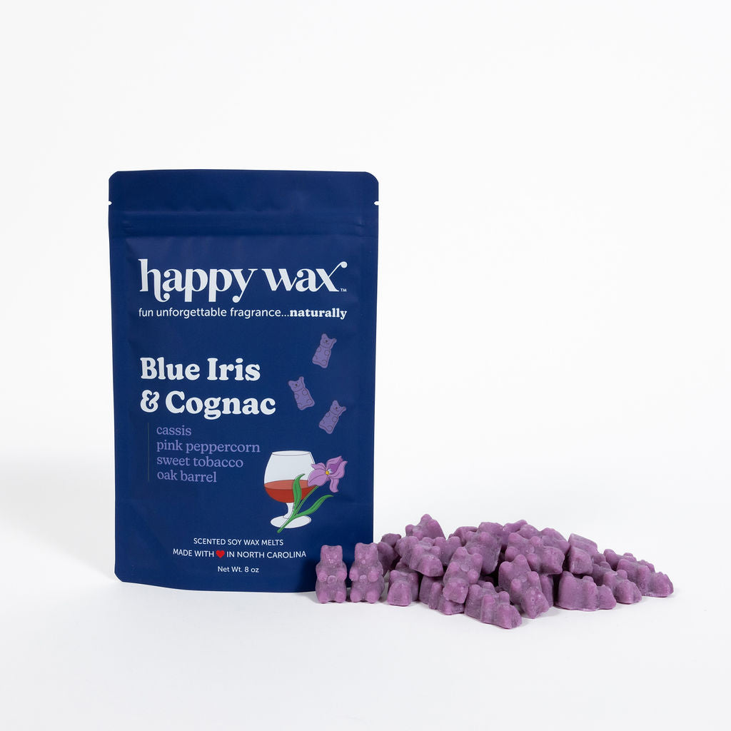 Blue resealable pouch of Happy Wax brand wax melts with purple chunks scattered beside it.