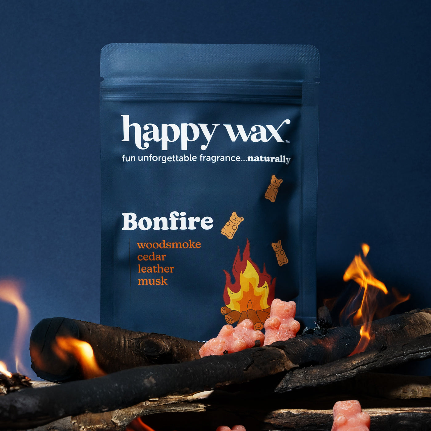 Blue resealable pouch of Happy Wax Bonfire wax melts with illustrated flame, logs, and pink crystals against dark background 