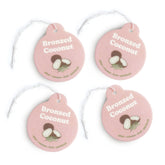 Four pink round car charms with "Bronzed Coconut" text, coconut illustrations, and scent descriptors, each with a white strin