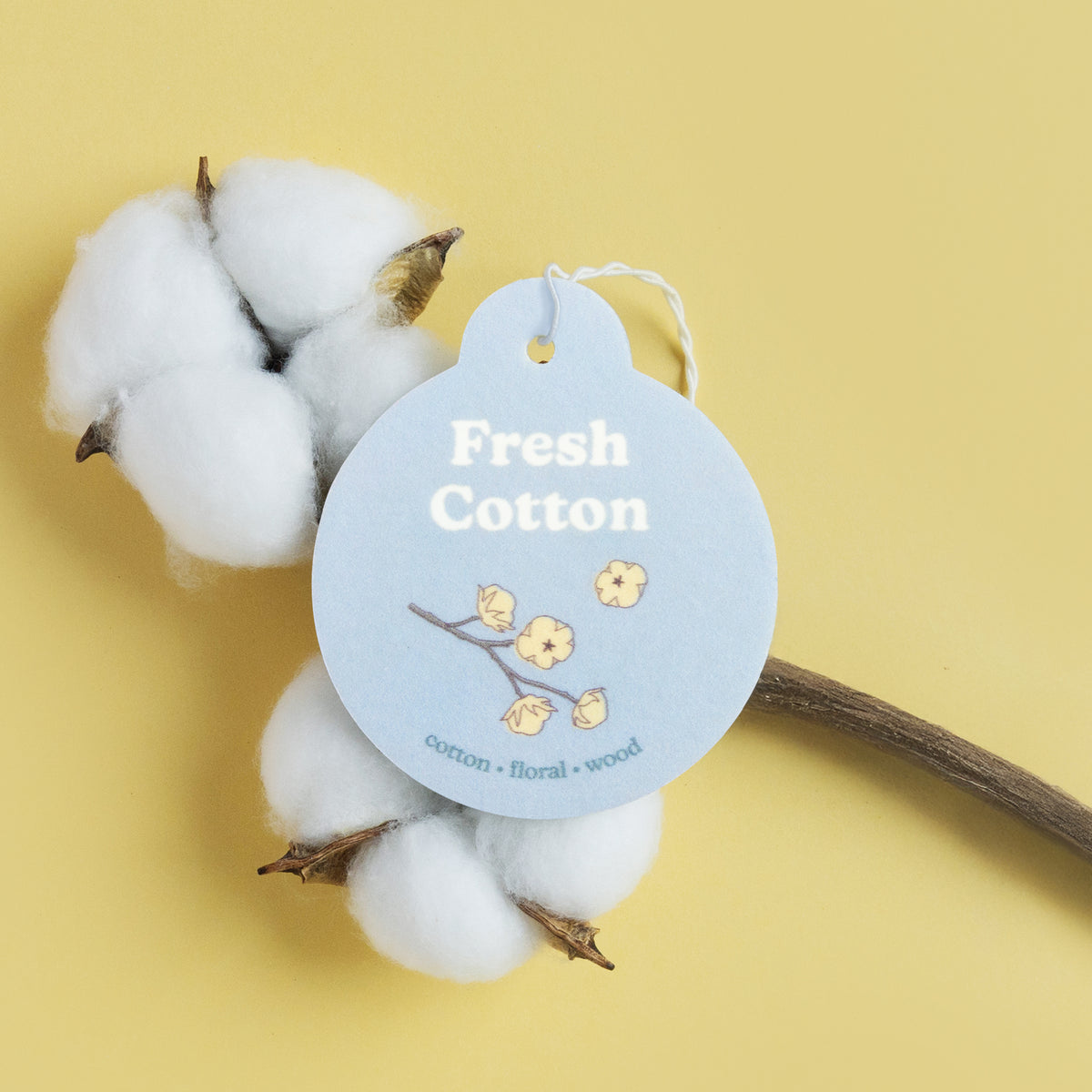 Light blue oval car charm with "Fresh Cotton" text and floral branch design, displayed with cotton plant and wooden stick on 