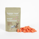 Tan pouch of Happy Wax Desert Torchwood wax melts with orange cube-shaped melts scattered beside it.