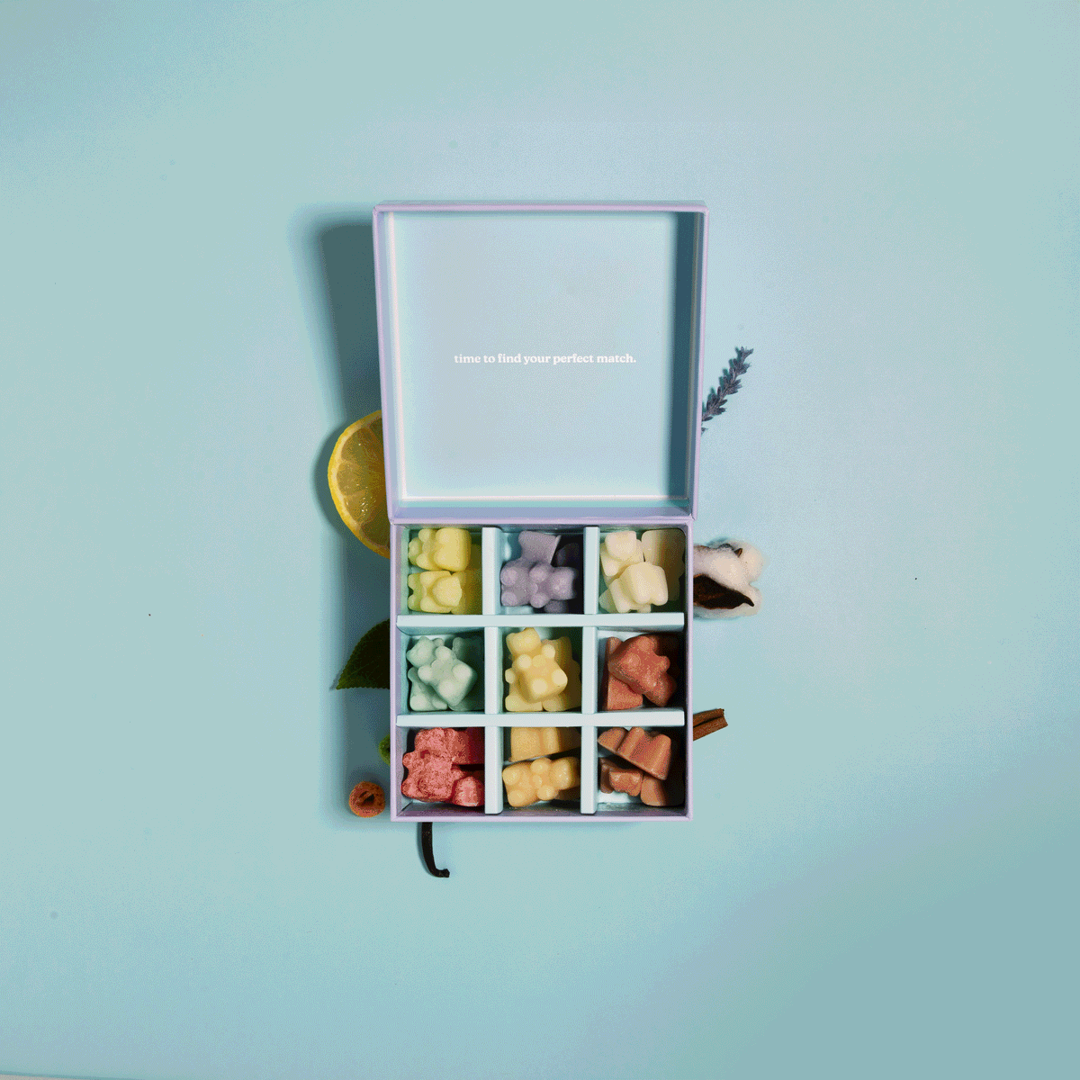 Wax melt discovery kit with nine compartments containing assorted colored wax melts in yellow, pink, and coral tones.