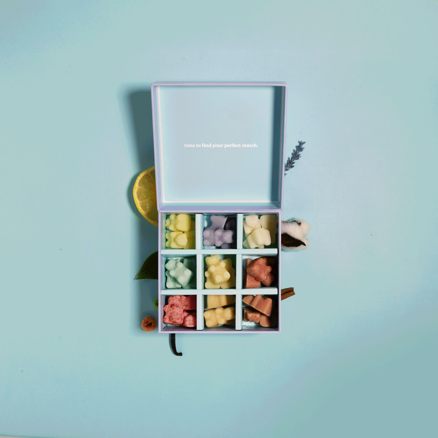 Wax melt discovery kit with nine compartments containing assorted colored wax melts in yellow, pink, and coral tones.