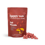 Red pouch of Happy Wax Fall Woods soy wax melts with scattered pink wax cubes displayed beside it.