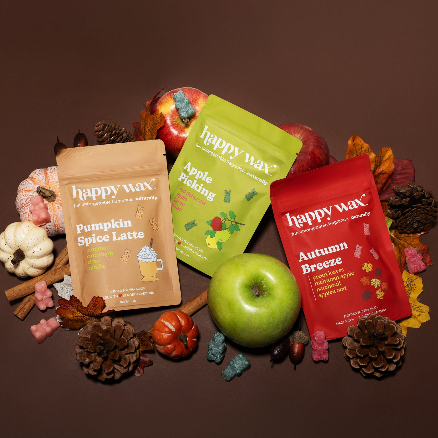 Happy Wax Forever Fall 3 pack with pumpkins, pine cones, fall leaves, and apples on a brown background.