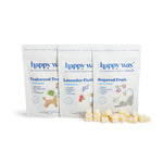 Three happy wax pouches labeled Teakwood Trail, Lavender Field, and Sugared Fruit with wax melts displayed in front.