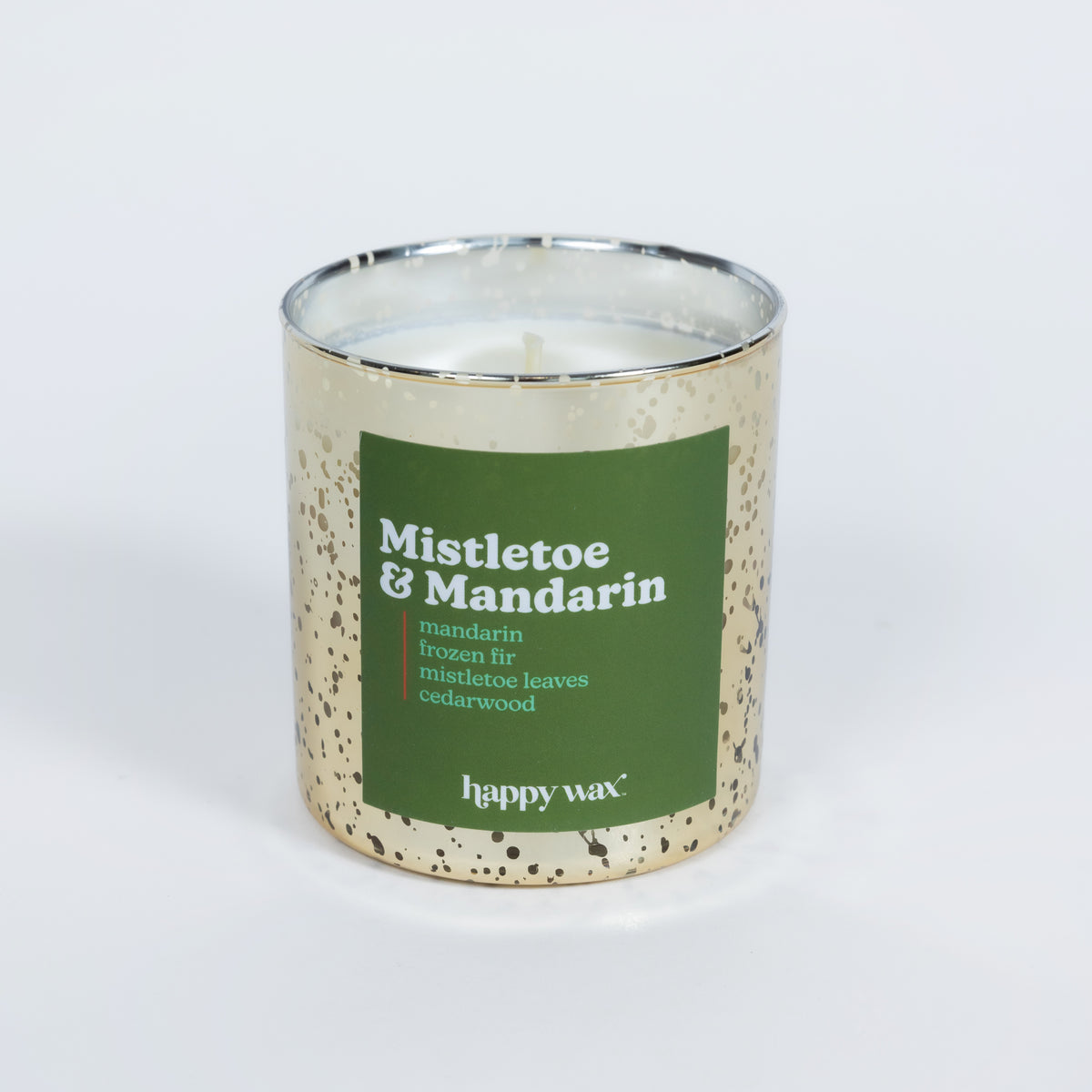 Cream-colored speckled candle jar with green label reading "Mistletoe & Mandarin" and single lit wick inside.