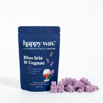 Navy blue pouch of Happy Wax brand Blue Iris & Cognac wax melts with purple wax pieces displayed in front.