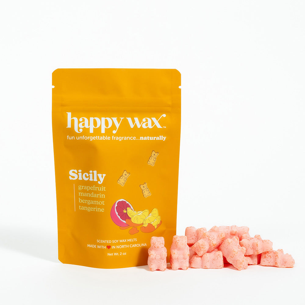 Golden orange pouch of Happy Wax Sicily scented soy wax melts with pink wax cubes displayed beside it.