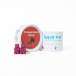 Pink bear-shaped wax melts next to a white container labeled "Pomegranate Grove" and happy wax branded packaging.