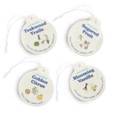Four cream-colored round car charms with string attachments labeled Teakwood Trails, Sugared Fruit, Golden Citrus, and Bloomi