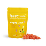 Yellow pouch of Happy Days soy wax melts with sunflower design, displayed with coral-colored wax melts scattered in front.