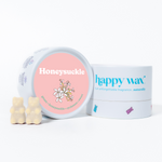 Cream-colored wax melts shaped as bears next to a pink and white container labeled Honeysuckle by happy wax.
