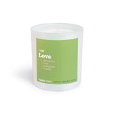 White cylindrical candle with green label reading "I AM Love" and scent notes of geranium, rose, petitgrain, and vanilla.