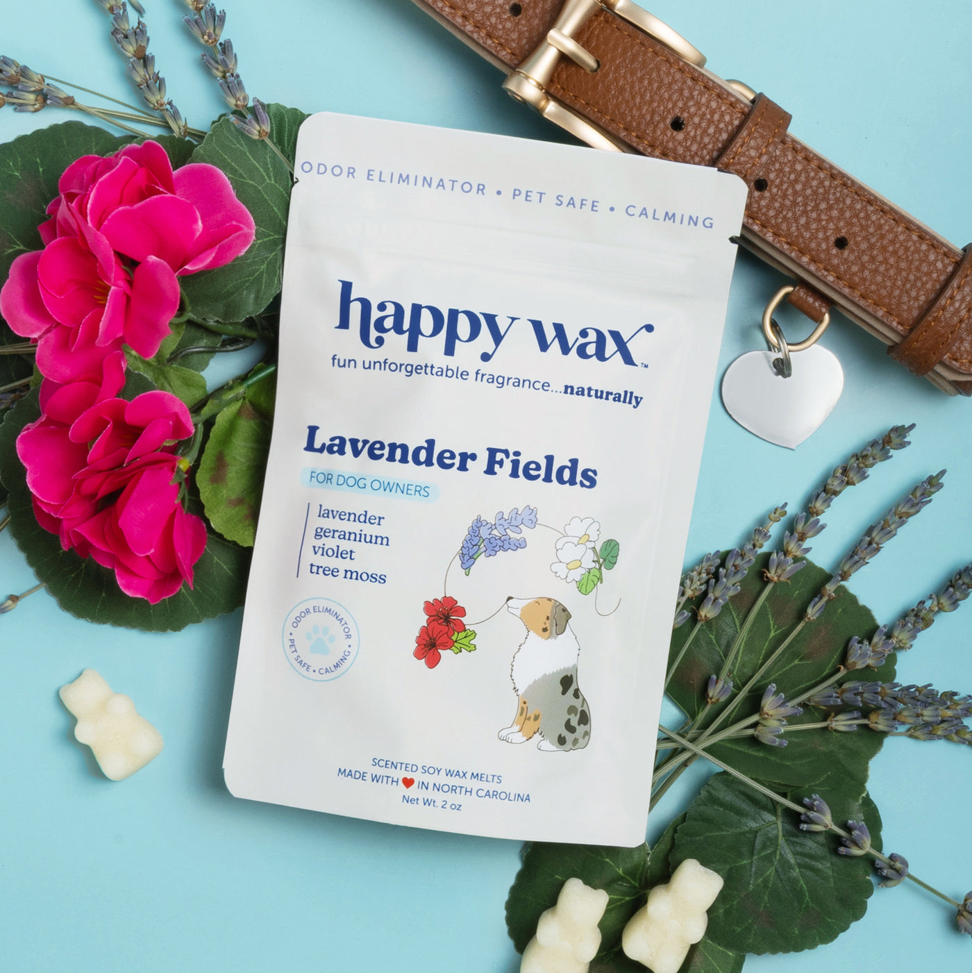 Happy Wax Lavender Fields pet wax melts package with cream-colored wax melts, surrounded by pink flowers, lavender sprigs, an