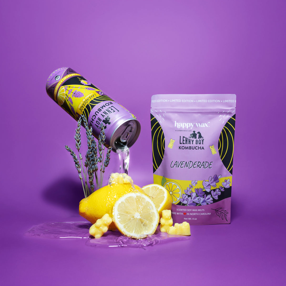 Purple pouch of Happy Wax Lavenderade wax melts surrounded by fresh lavender sprigs, sliced lemon, and a beverage can on purp