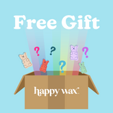 Brown cardboard box labeled "happy wax" with colorful gummy bear shapes and question marks emerging from top against light bl