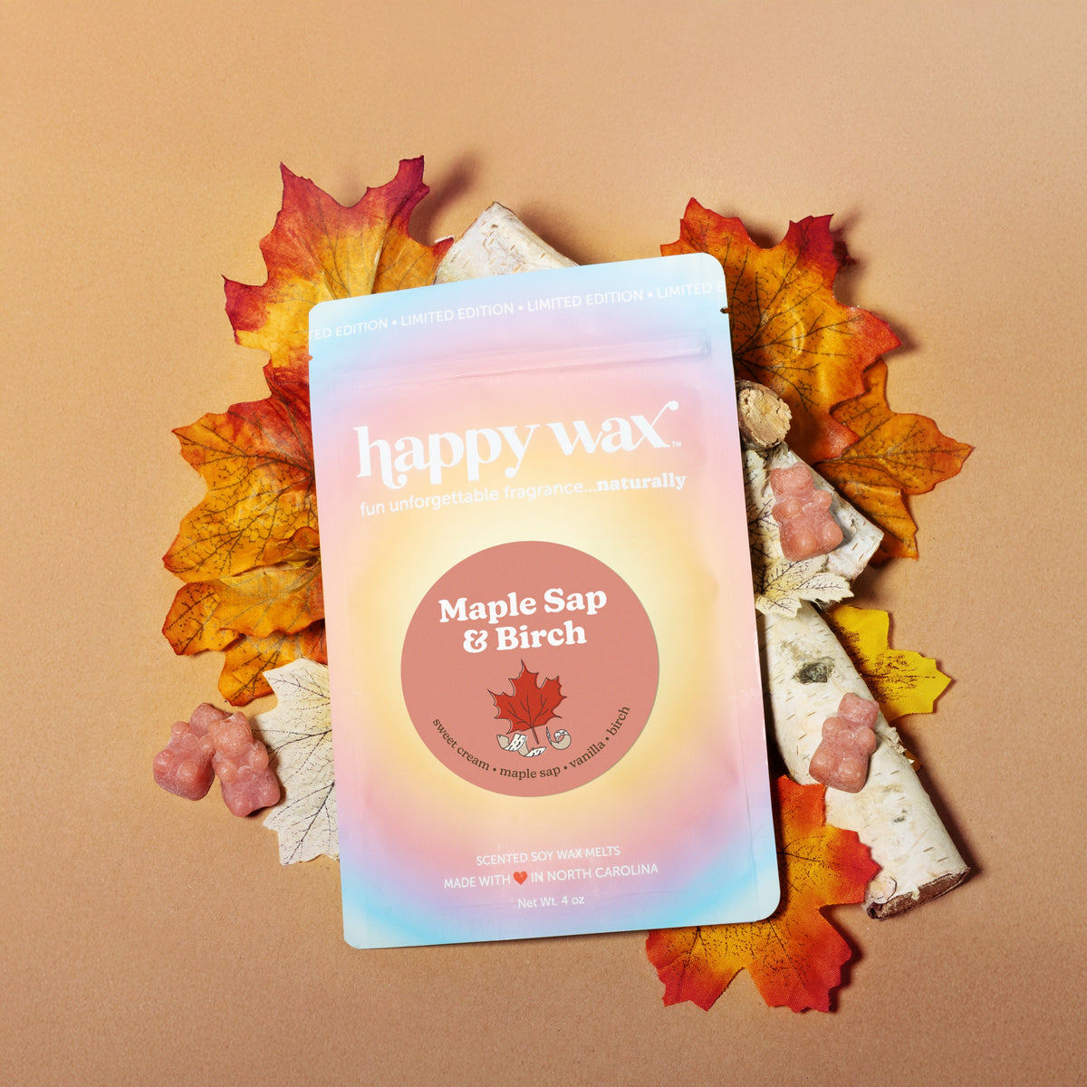 Happy Wax brand soy wax melts in Maple Sap & Birch scent, displayed with autumn leaves and wax pieces on tan background.