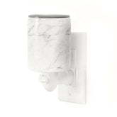 White marble-textured plug-in wax warmer with gray top and outlet prong attachment.