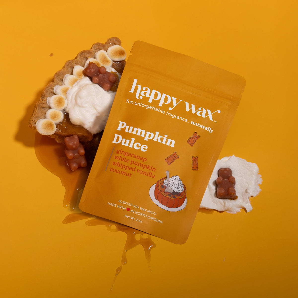 Orange pouch of Pumpkin Dulce wax melts surrounded by brown and white wax pieces on yellow background.