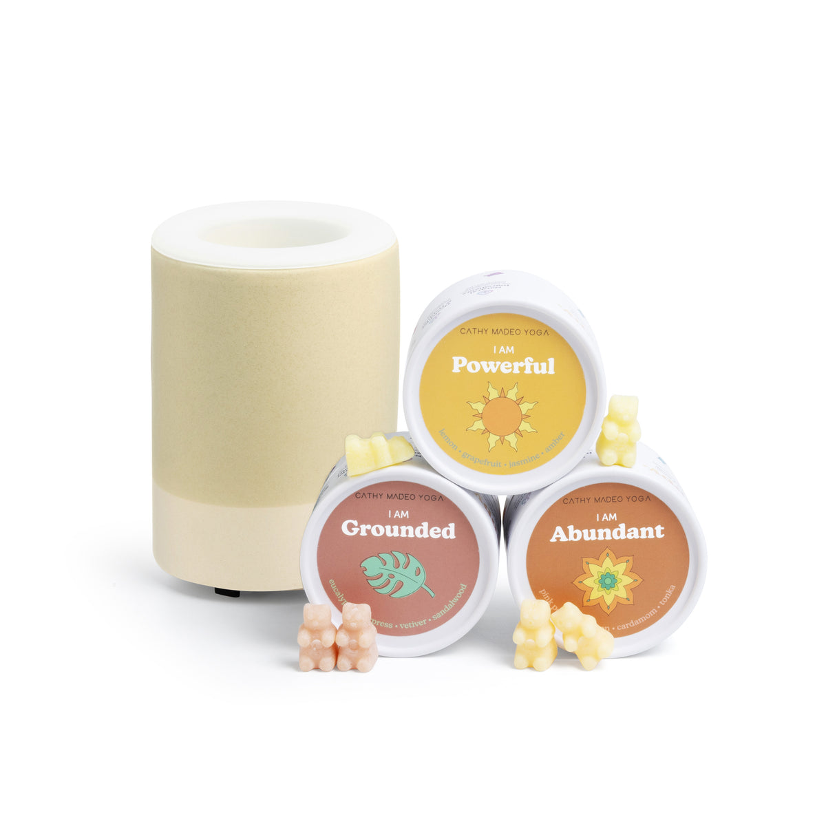 Cream-colored wax warmer with three labeled wax melts in yellow, red, and orange, plus loose wax pieces in pink and yellow.