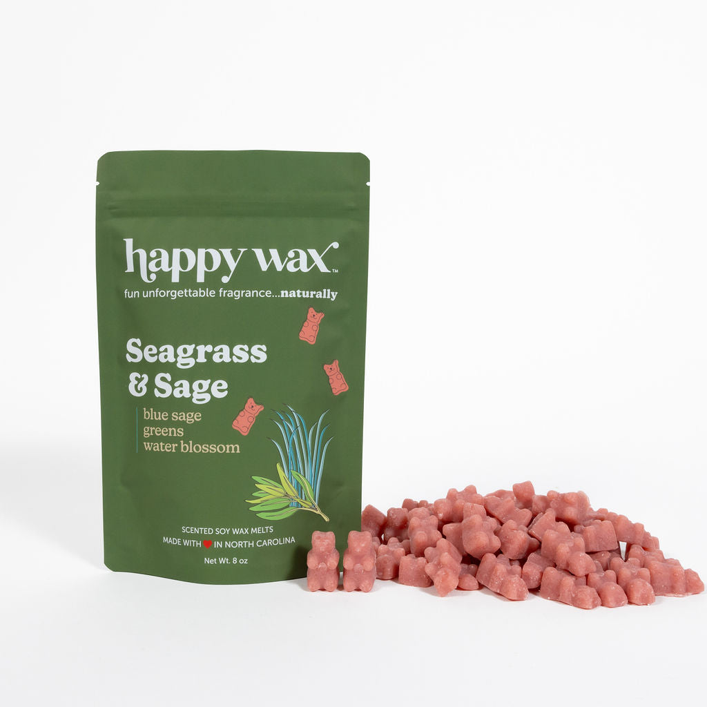 Green pouch of Happy Wax brand Seagrass & Sage wax melts with coral-colored wax pieces displayed beside it.