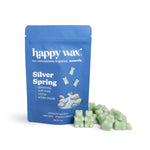 Blue pouch of Happy Wax Silver Spring soy wax melts with pale green wax melts displayed in front.