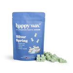 Blue pouch of Happy Wax Silver Spring soy wax melts with green wax pieces displayed in front.