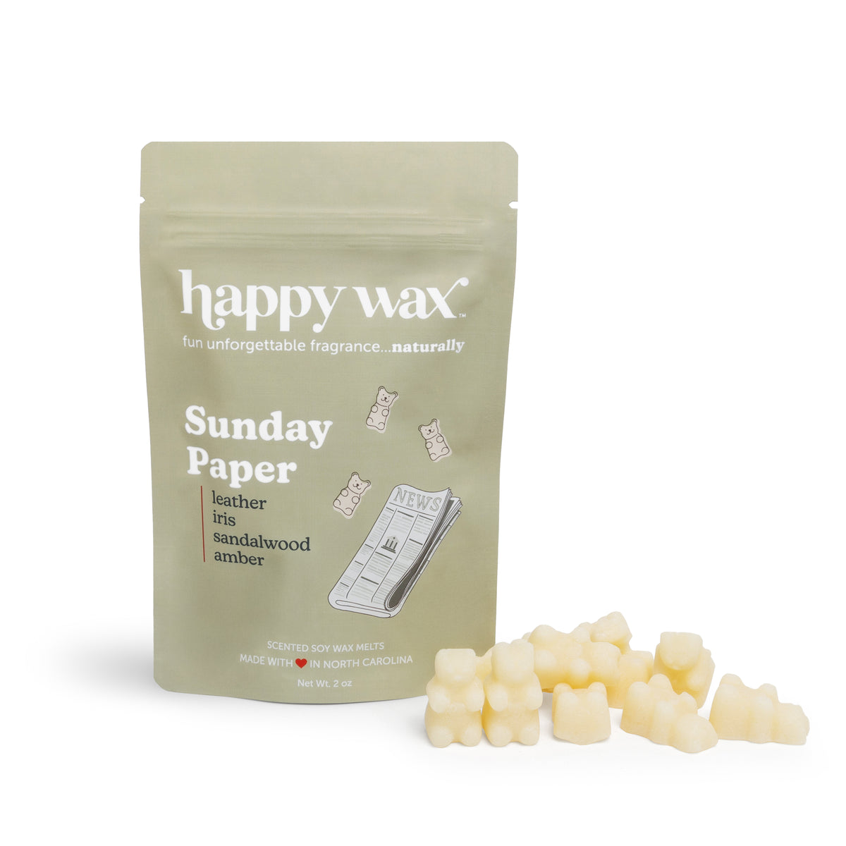 Cream-colored wax melts next to a sage green pouch labeled "Sunday Paper" with scent notes and happy wax branding.